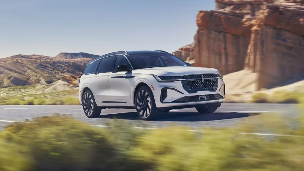 White 2025 Lincoln Nautilus® SUV cruising in desert landscape with motion blur effect.