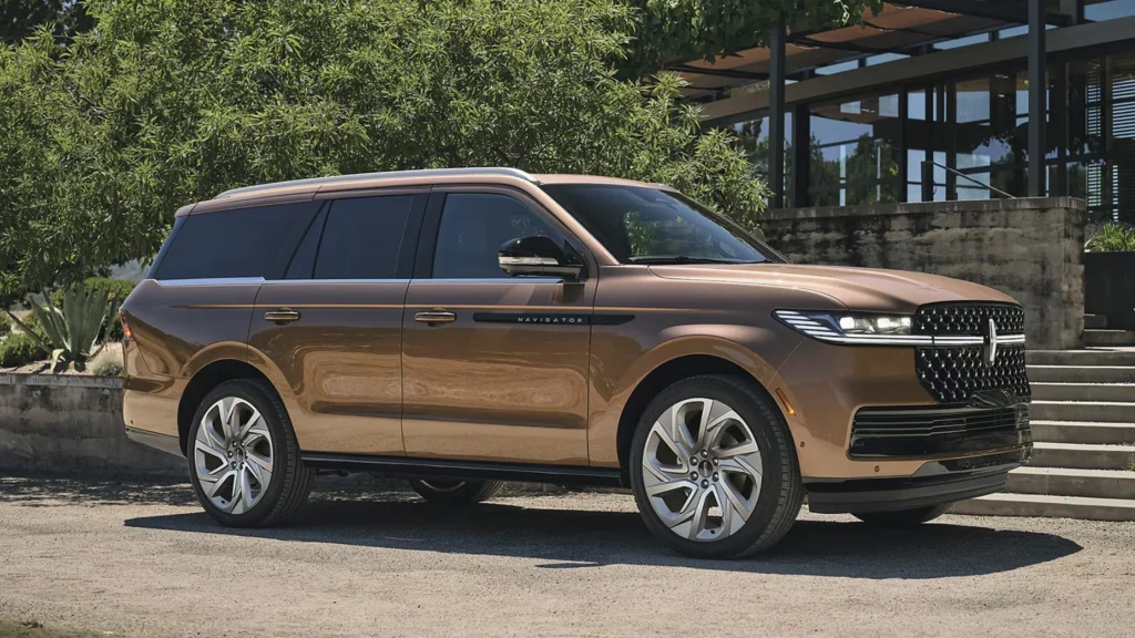Bronze 2025 Lincoln Navigator® parked near modern house with lush landscaping in background.
