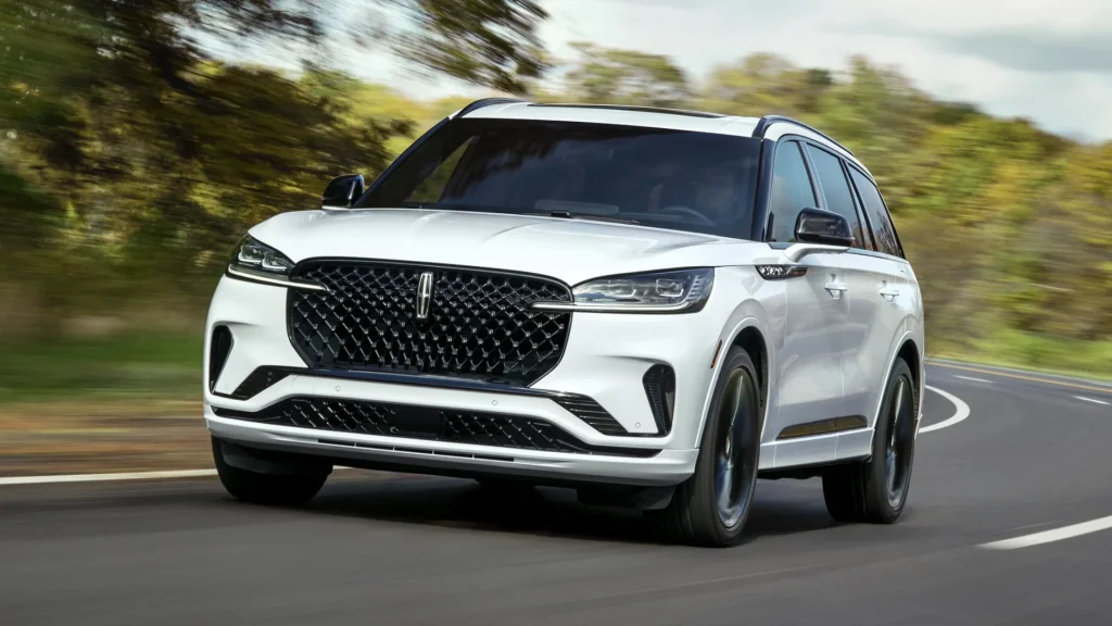 2025 Lincoln Aviator Reserve in motion on a scenic road with white body and bold front fascia.