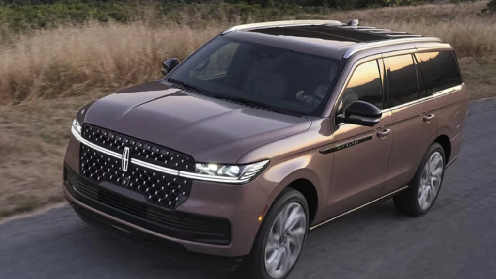 2025 Black Label Navigator® driving past fields showcasing bold grille and panoramic roof.