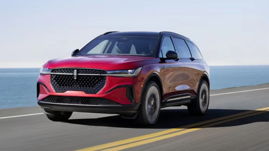 2026 Nautilus® in red cruising on coastal highway with modern grille and two-tone roofline.