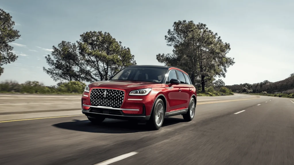 2025 Lincoln Corsair® Reserve driving on highway with chrome grille and luxury compact SUV profile.