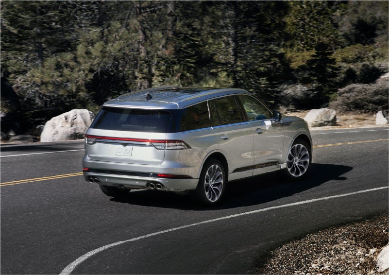 A 2023 Lincoln Aviator® Grand Touring model is shown being driven on a tight turn of a mountain road | Nick Mayer Lincoln Westlake in Westlake OH
