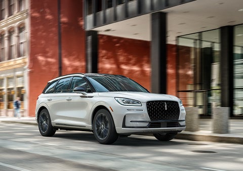 The 2024 Lincoln Corsair® SUV with the Jet Appearance Package and a Pristine White exterior is parked on a city street. | Nick Mayer Lincoln Westlake in Westlake OH