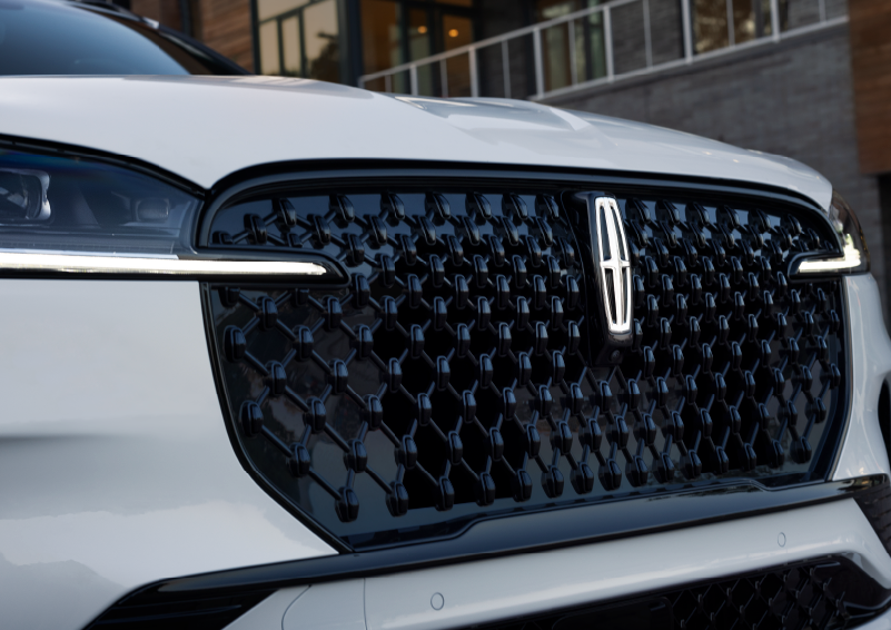 The black grille of a white 2025 Lincoln Aviator® SUV is shown with its fog lights on. | Nick Mayer Lincoln Westlake in Westlake OH