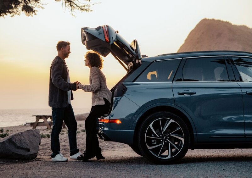 A couple share a moment together outside a 2025 Lincoln Corsair® SUV near the open liftgate. | Nick Mayer Lincoln Westlake in Westlake OH