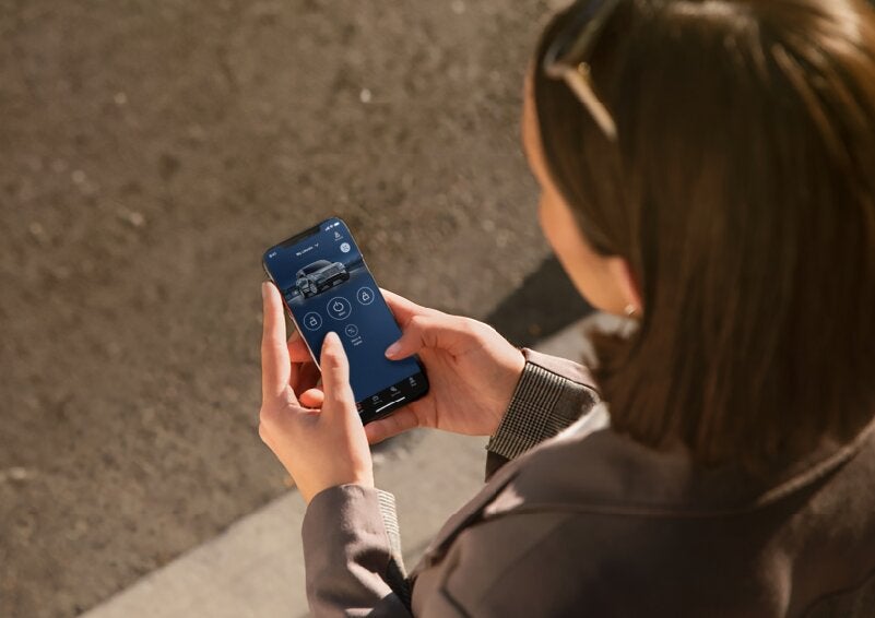 A person is shown interacting with a smartphone to connect to a Lincoln vehicle via the Lincoln Way® App. | Nick Mayer Lincoln Westlake in Westlake OH