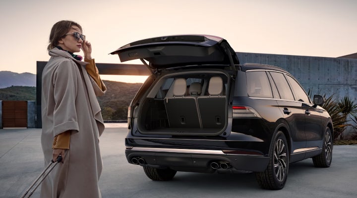 A woman approaches a 2026 Lincoln Aviator® SUV with its rear liftgate open. | Nick Mayer Lincoln Westlake in Westlake OH