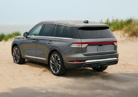 A 2027 Lincoln Aviator® SUV is parked next to sand dunes. | Nick Mayer Lincoln Westlake in Westlake OH