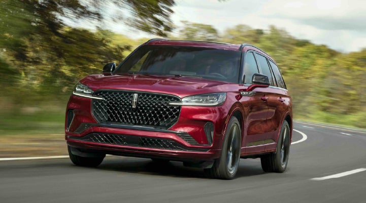 A 2027 Lincoln Aviator® SUV is being driven on a country road | Nick Mayer Lincoln Westlake in Westlake OH