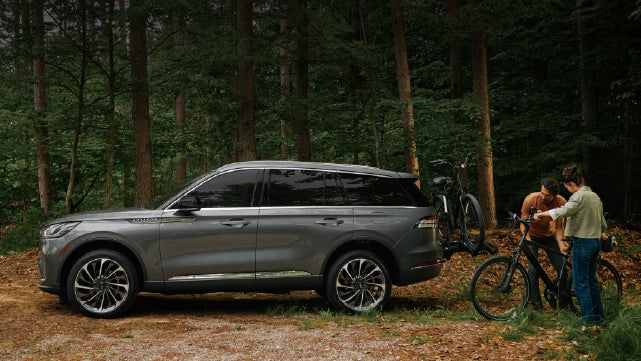 A father and son load e-bikes on a bike rack attached to a 2027 Lincoln Aviator® SUV. | Nick Mayer Lincoln Westlake in Westlake OH