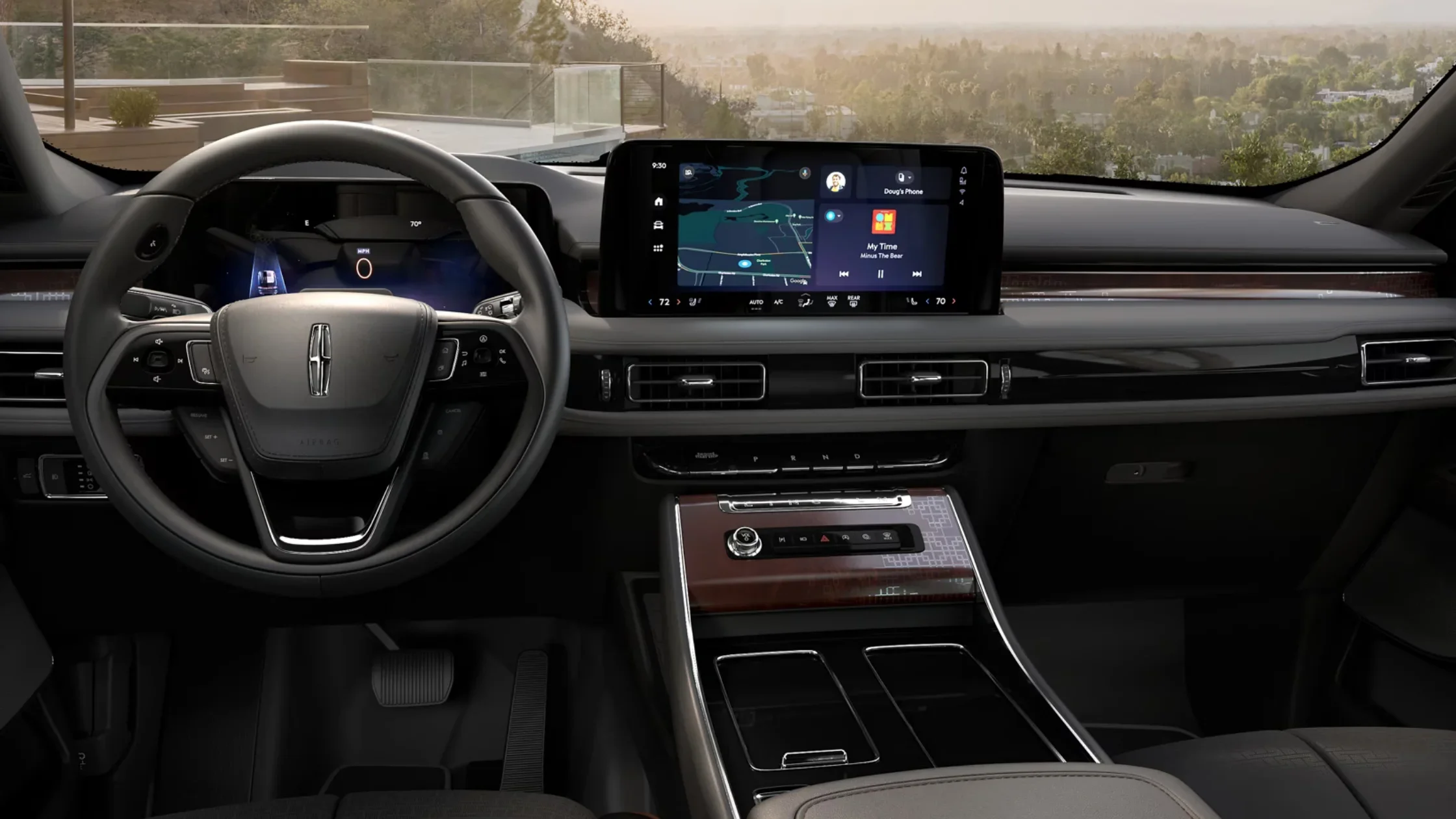 Driver’s cockpit view of the 2025 Lincoln Black Label Aviator® interior, featuring wood grain trim, a digital display, and a wide center console with ambient lighting.