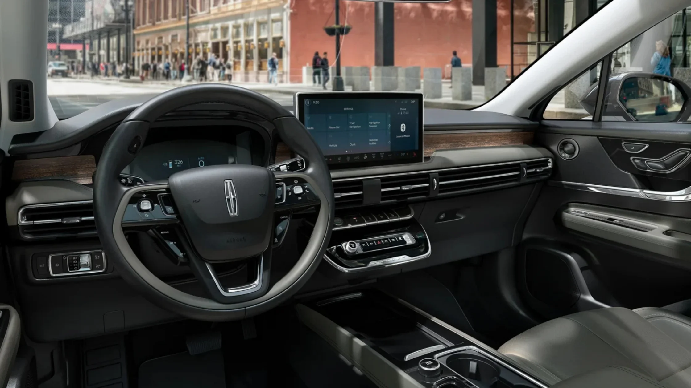 2025 Corsair® Reserve interior front cabin with leather-wrapped steering wheel, touchscreen, and wood trim accents.