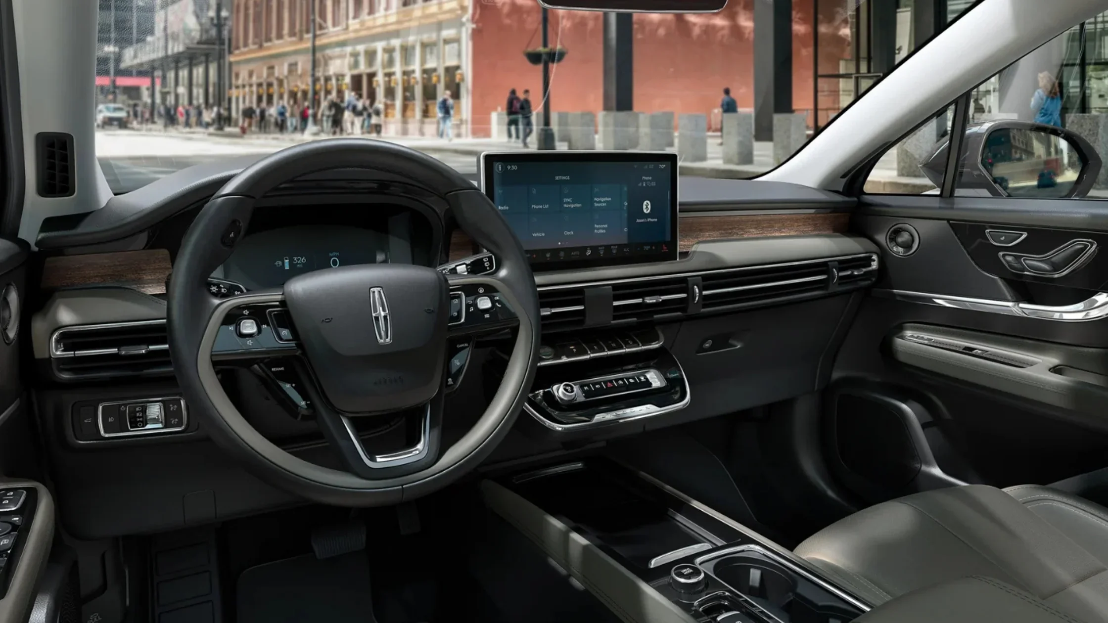Driver-focused interior of the 2025 Lincoln Corsair® Reserve featuring a digital cluster, large center display, and woodgrain accents.
