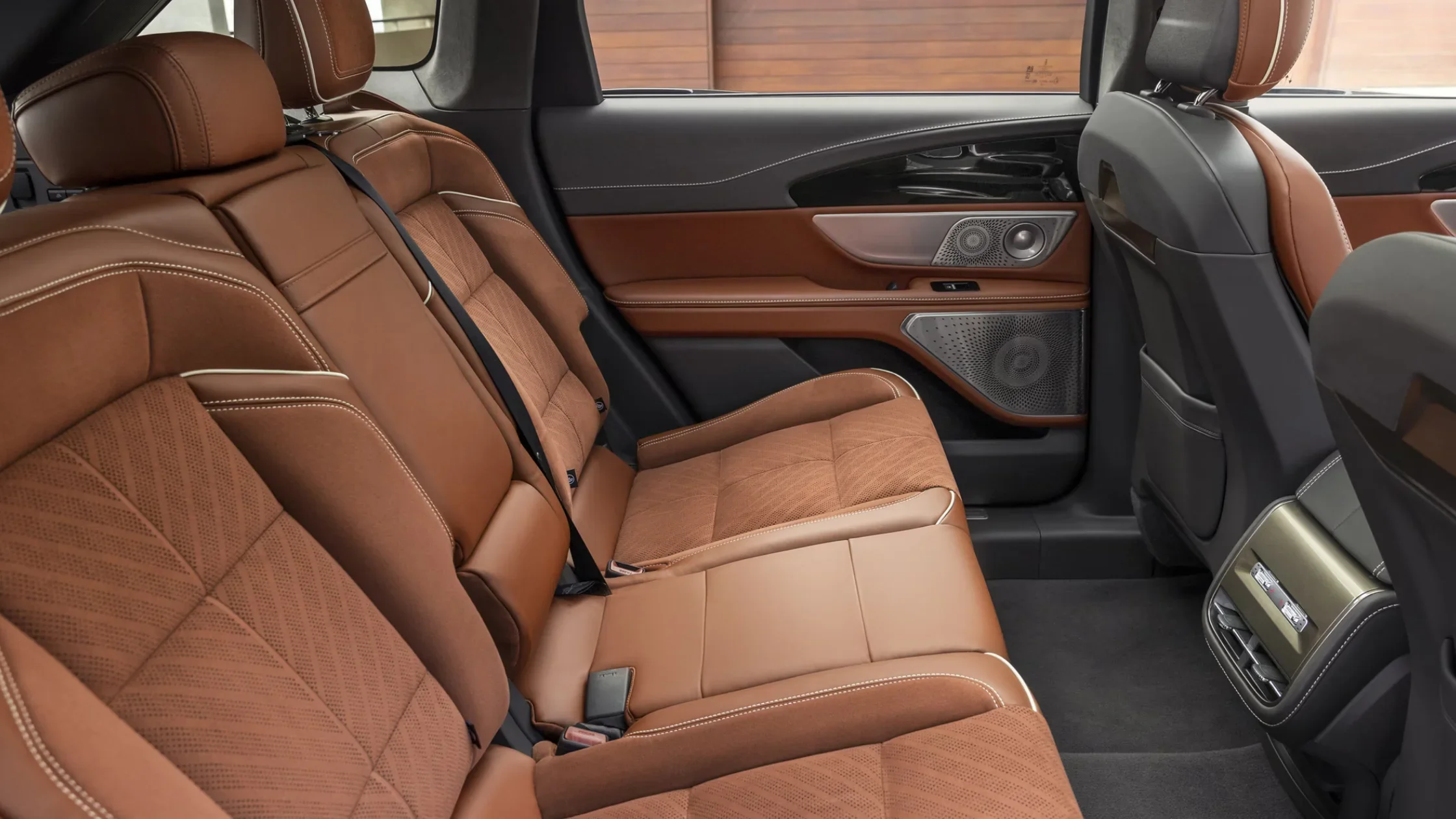 Rear seat close-up of the 2025 Lincoln Black Label Nautilus® showing tan leather upholstery, contrast stitching, and door speaker design.