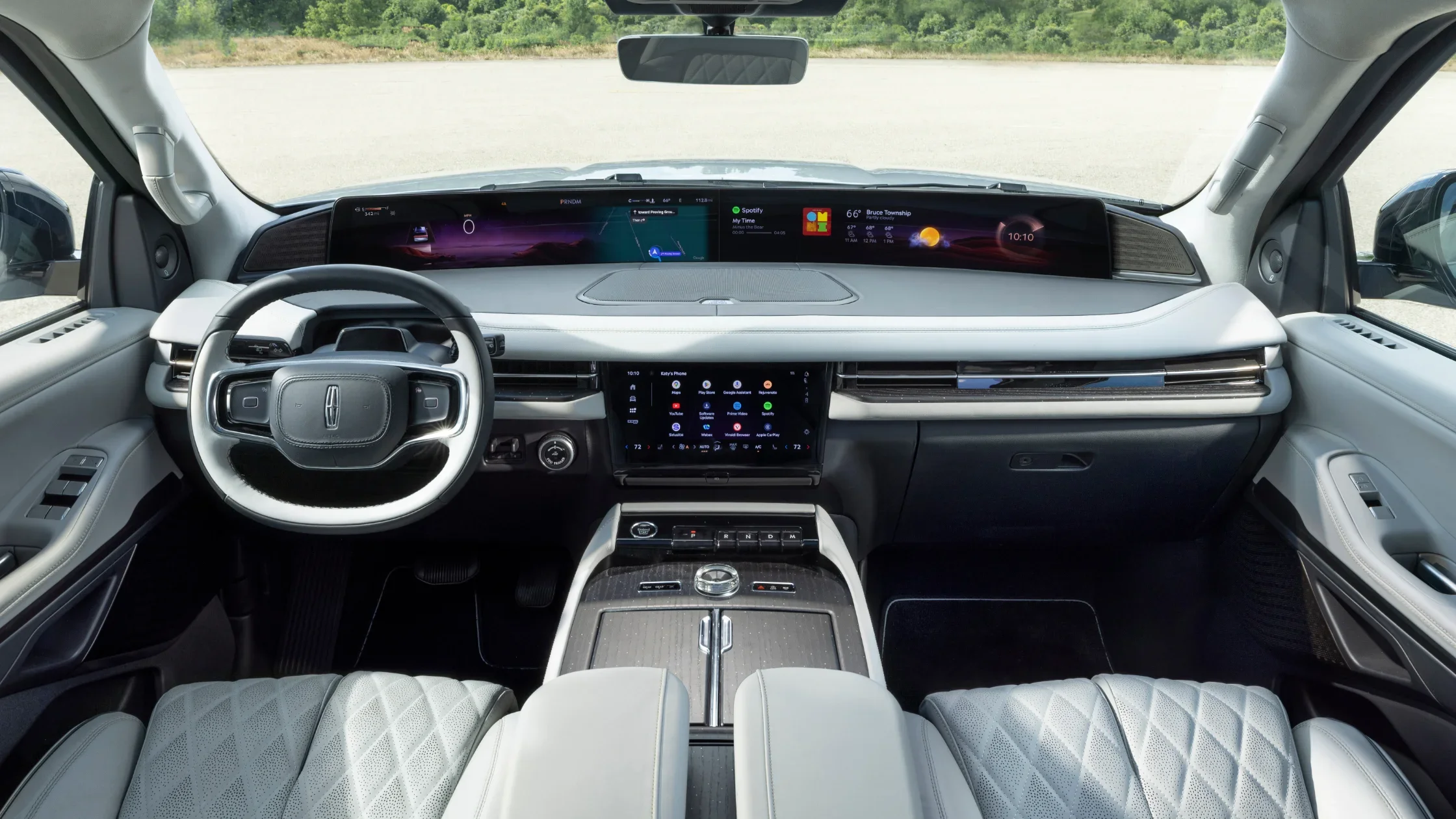 Driver’s cockpit view of 2025 Lincoln Black Label Navigator® with curved digital display and leather-wrapped steering wheel.