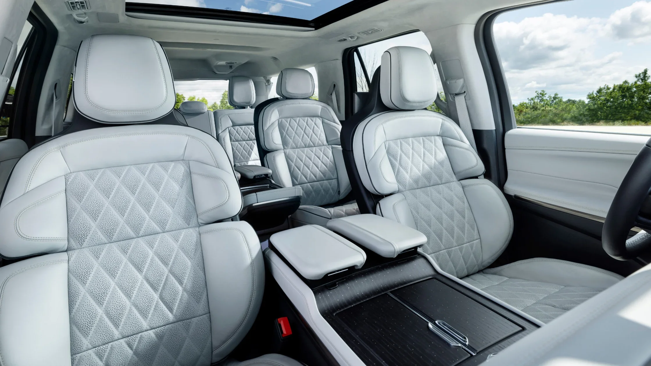 Luxurious white leather interior of 2025 Lincoln Black Label Navigator® featuring captain’s chairs and panoramic sunroof.
