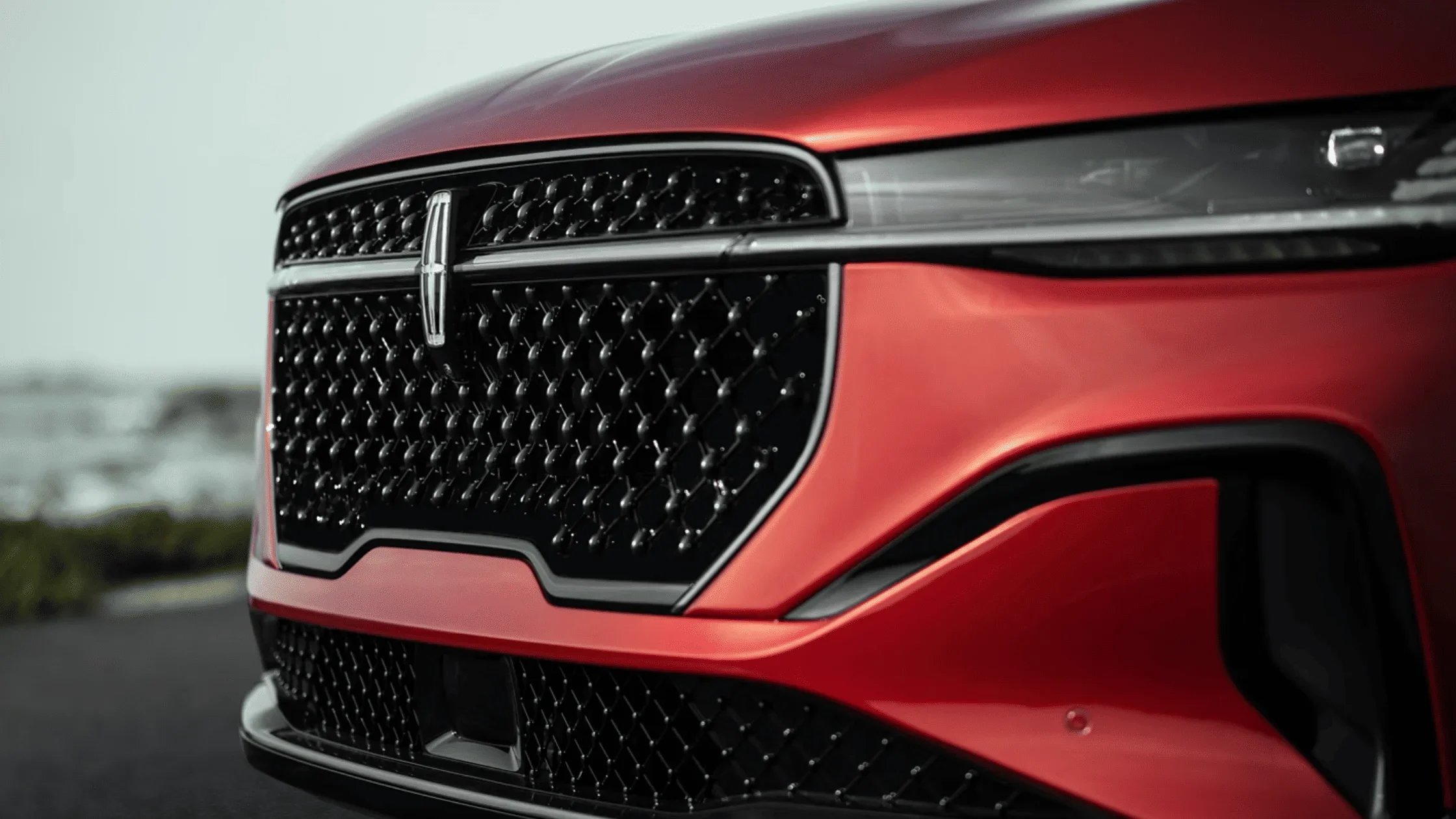 Close-up of 2025 Lincoln Nautilus® Reserve grille design in metallic red finish