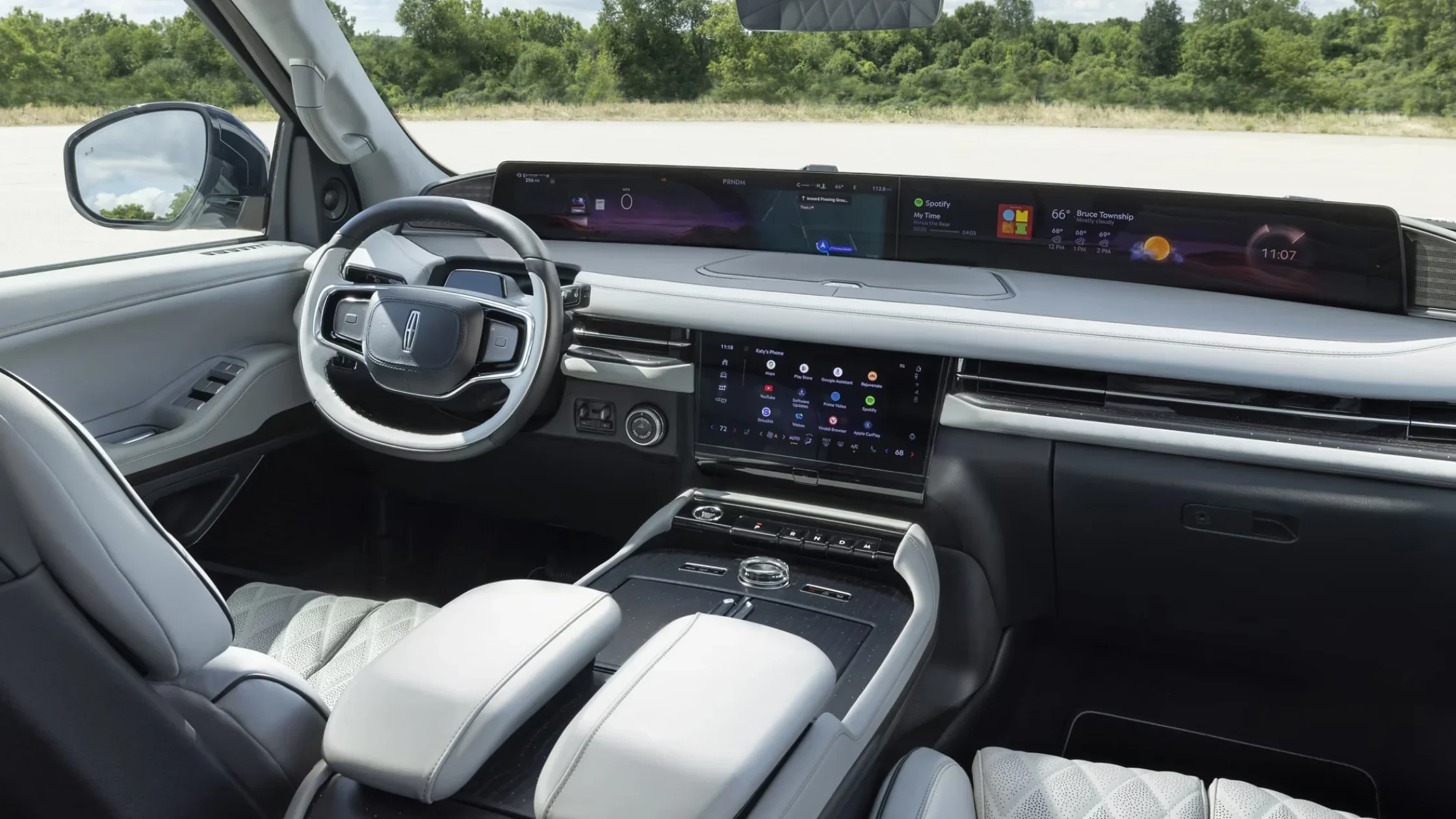 Premium front cabin of the 2025 Lincoln Navigator® Reserve, featuring diamond-stitched leather seats, panoramic digital displays, and a sleek rotary gear selector.