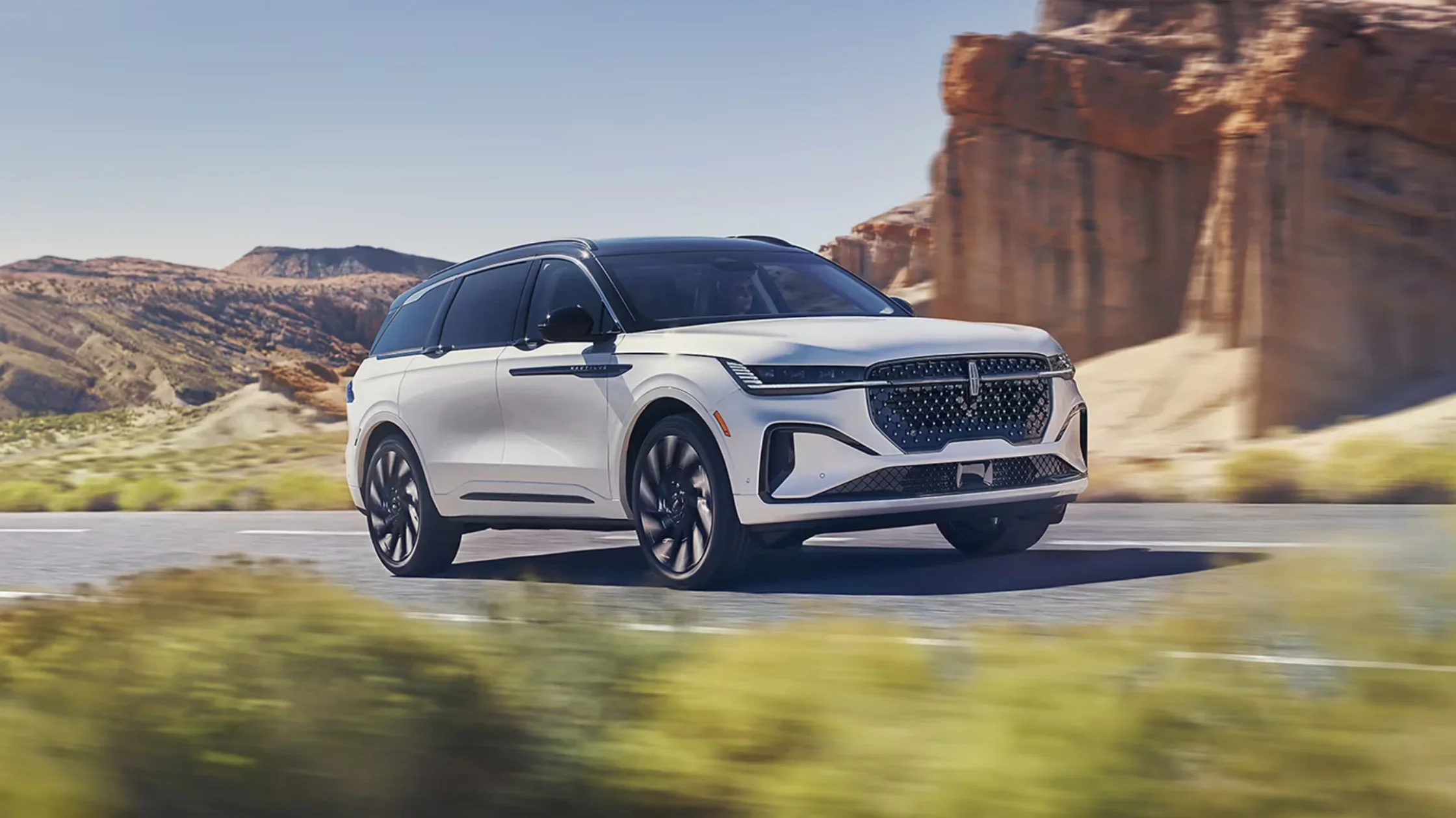 2026 Nautilus® exterior in motion on open road, finished in white with bold grille and sleek modern headlights.