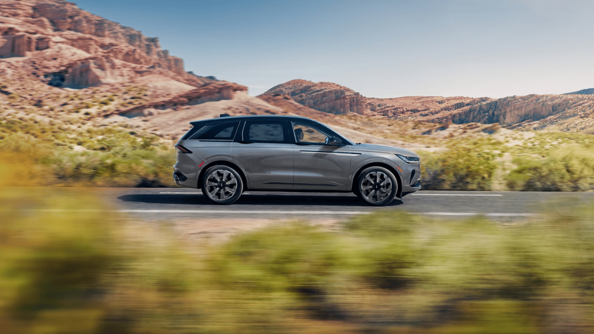 2026 Lincoln Nautilus® front exterior driving on curved road with motion blur.