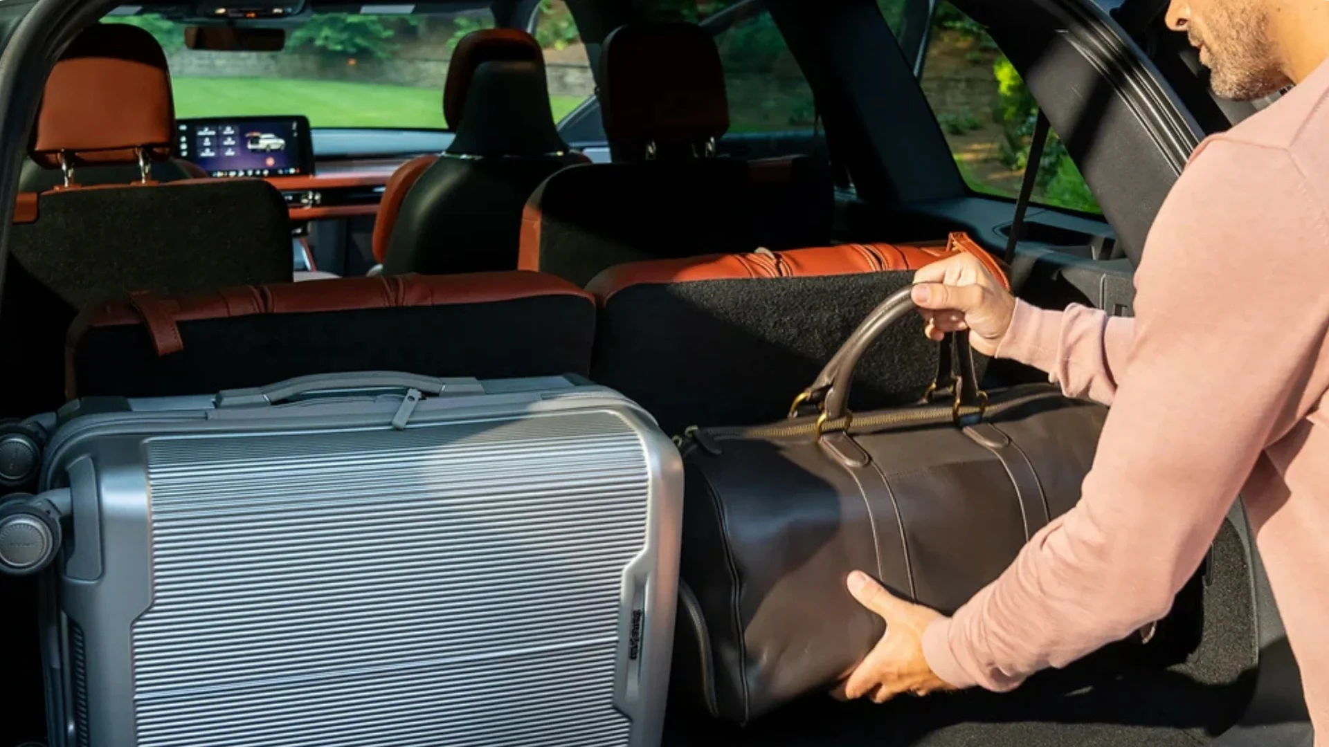 Cargo area of a 2025 Aviator® Reserve with luggage being loaded, highlighting practical storage space and flexible seating.