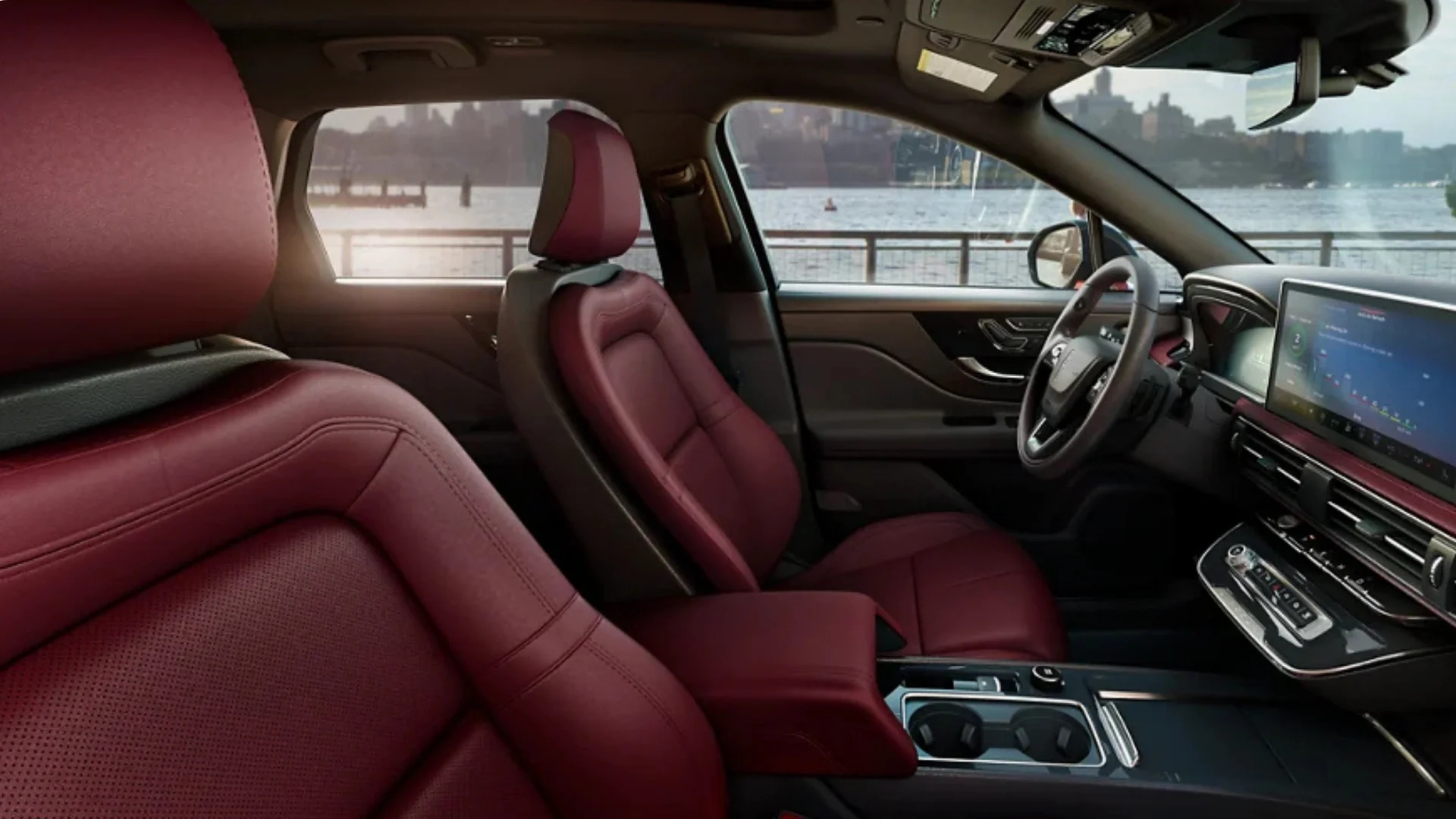 Front cabin view of the 2025 Lincoln Corsair® Reserve featuring premium red leather seats, a panoramic windshield view, and a modern dashboard with a digital display.