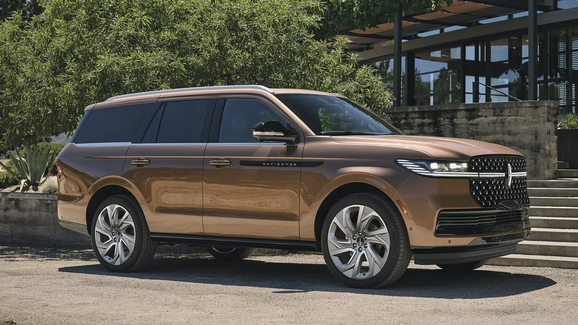 Side view of the 2025 Lincoln Navigator Reserve in metallic bronze parked outdoors, emphasizing its elegant SUV profile, chrome accents, and premium styling.