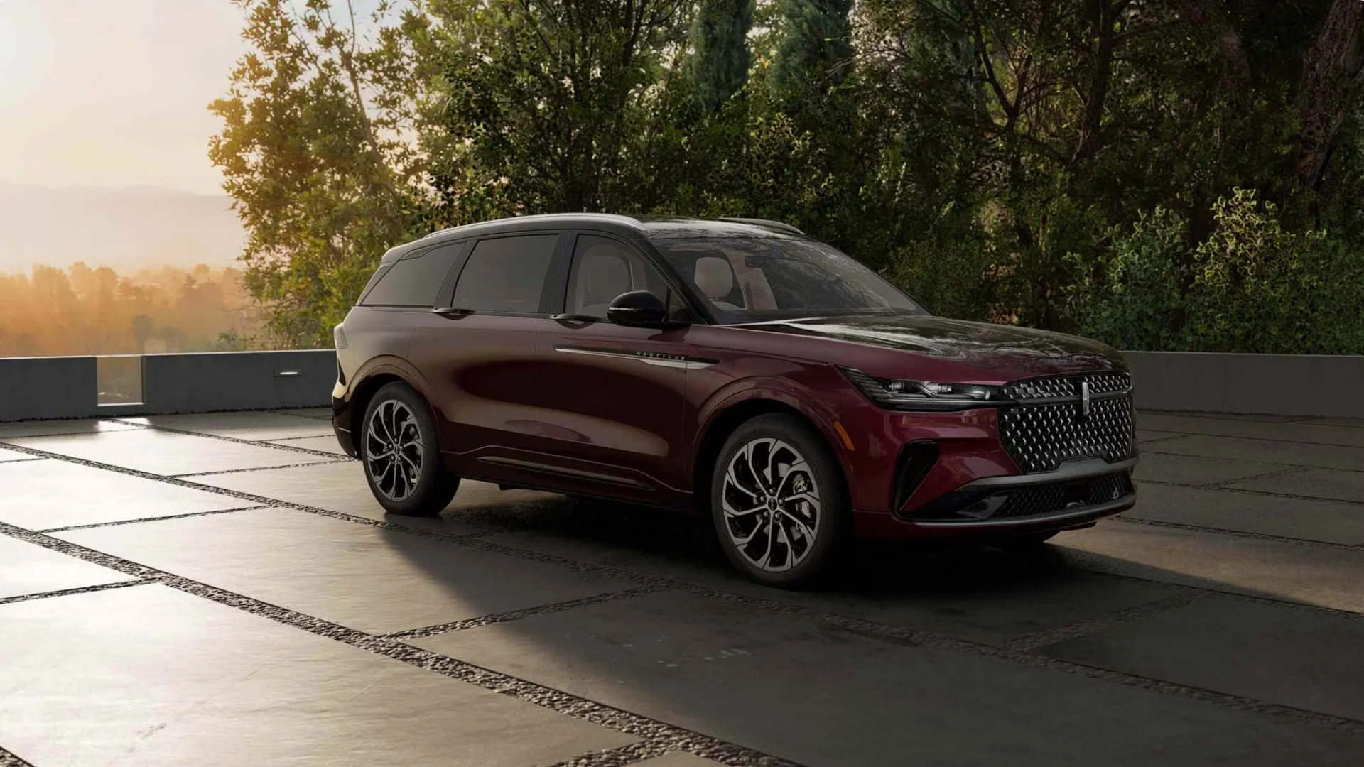 2026 Lincoln Nautilus in burgundy parked on a modern terrace at sunset.
