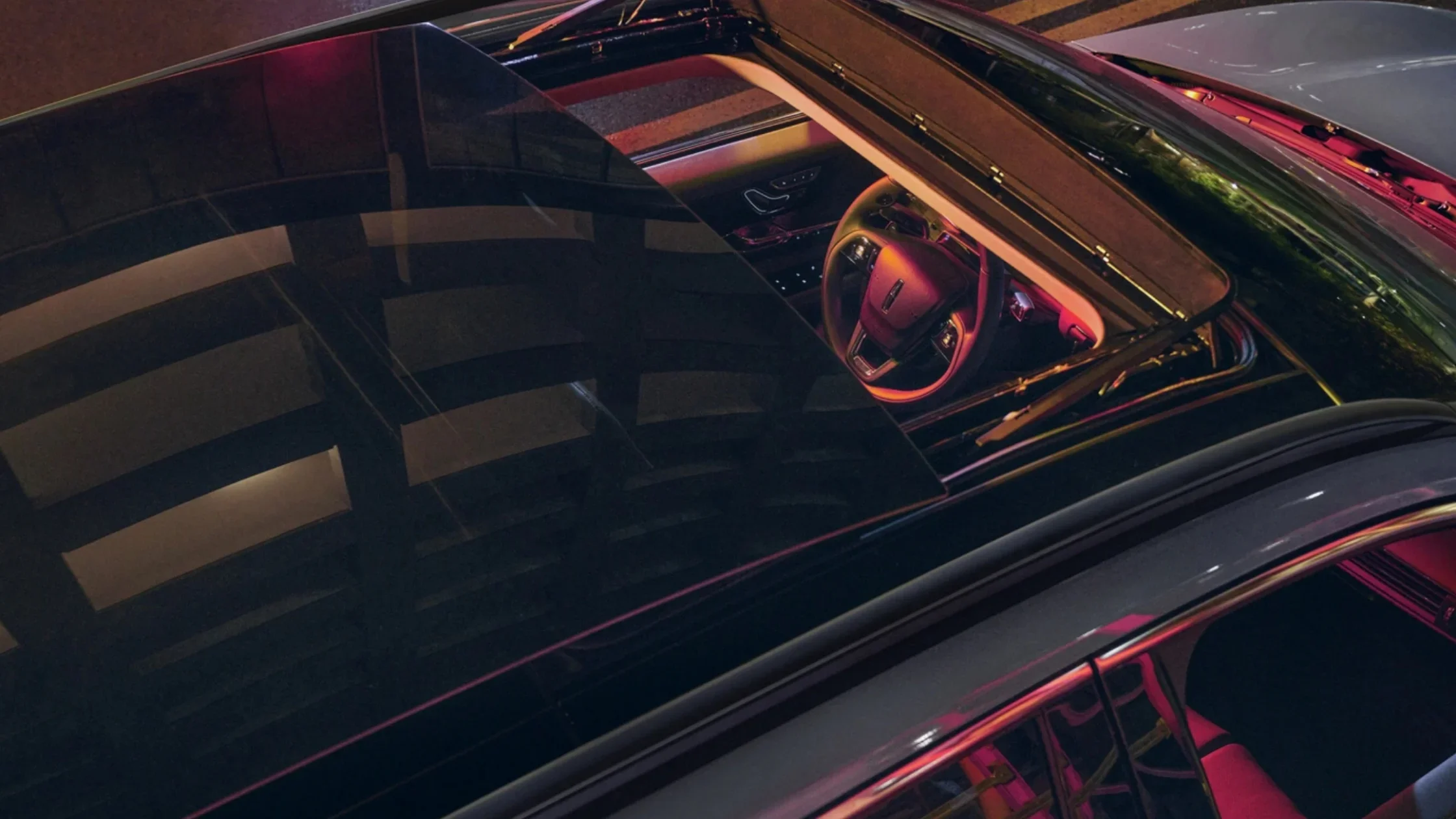 2025 Corsair® Grand Touring panoramic roof view showing interior lighting and steering wheel from above.